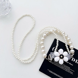Macro shot of white pearl phone lanyard with elegant flower clasp and lobster hook