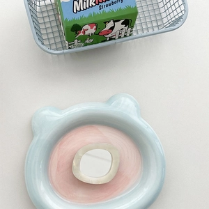 Macro detail of a light blue bear-shaped ceramic tray with a pink center and resin accessory