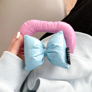 Close-up of pink padded tube and blue bow strap detail on a premium leather phone case