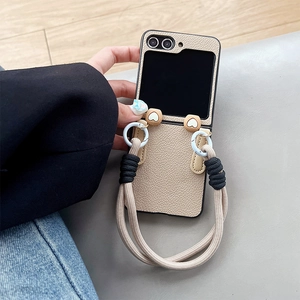 Macro shot of beige lychee leather Z Flip case with cute heart-shaped metal rope hooks