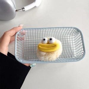 Detail of plush cartoon phone socket with big eyes and yellow mouth in blue mesh basket