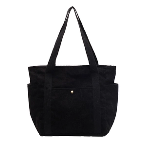 Black corduroy tote bag with front pocket and side pockets on white background