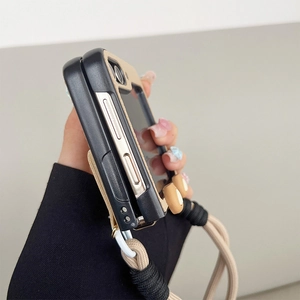 Close-up of leather folding phone case with woven lanyard and hinge protection detail