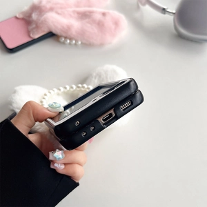 Détail de la coque pliante avec oreilles de lapin en peluche et bracelet en perles