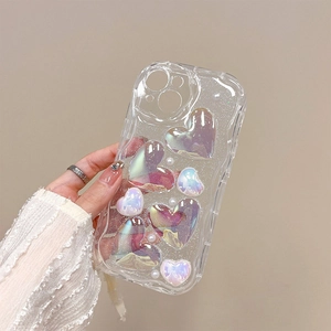 Close-up of holographic 3D hearts and white pearls on a glittery iPhone protective case