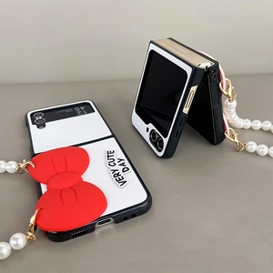 Detail of Galaxy Z Flip case with 3D red bow, pearl strap, and Very Cute Day text