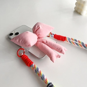 Detail of clear phone case with pink fabric bow and colorful braided crossbody strap