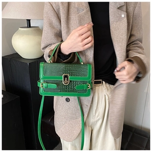 Detail of green crocodile texture PU leather crossbody bag with stylish metal buckle clasp