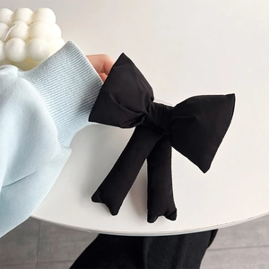 Close-up of a large black bow-knot phone case back clip accessory with soft fabric texture