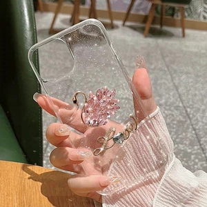 Détail de la coque iPhone pailletée avec cygne en cristal rose et breloque Love dorée