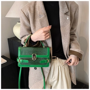 Detail shot of green crocodile pattern PU leather crossbody bag with metal twist lock