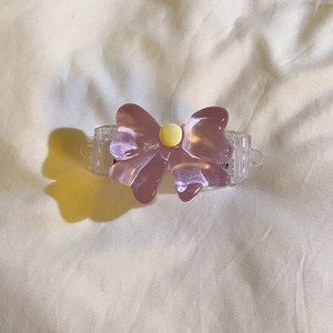 Close-up of a purple translucent resin bow attachment with a yellow center button