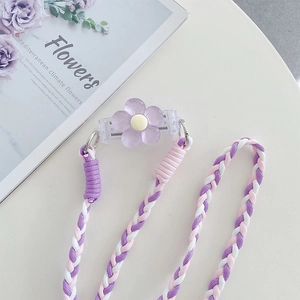 Macro detail of purple floral clip and pink braided crossbody phone strap with adjustable cord