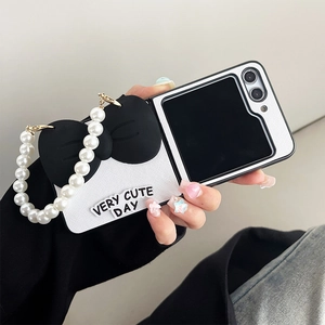 Detail of Z Flip case with pearl strap, large black bow and VERY CUTE DAY text
