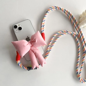 Detail of pink fabric bow and colorful braided crossbody strap for smartphone case