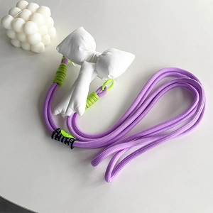 Detail of purple woven phone strap with a white fabric bow and green cord accent