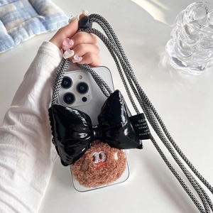 White iPhone case with black lacquer bow, plush cookie charm and woven crossbody strap