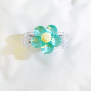 Close-up of cyan 3D resin flower phone clip with transparent base and yellow center