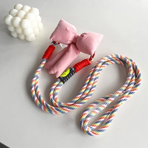 Colorful braided phone strap with large pink bow and smiley face charm detail