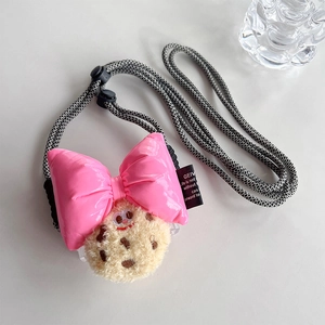 Detail of plush biscuit doll with pink leather bow and adjustable braided lanyard strap