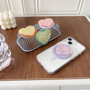 Close-up of heart-shaped glitter phone grips in multiple colors on a phone back