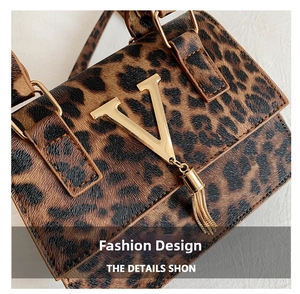 Dettaglio della mini borsa leopardata con logo V dorato e nappine metalliche
