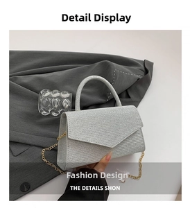 Detail of silver sequined square bag with gold metal chain and top handle