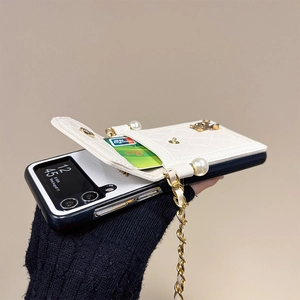 Detailed view of white quilted leather phone case with card slot and gold pearl chain