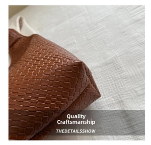 Macro shot of brown woven leather texture and reinforced stitching on tote bag corner