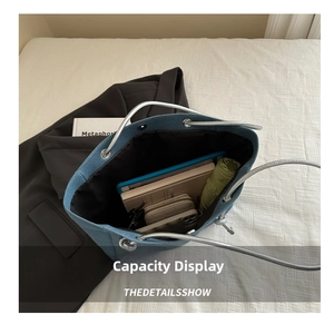 Spacious interior of denim tote bag showing tablet, books, and green umbrella