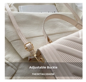 Detail of adjustable golden buckle and V-shaped quilted leather strap on a beige bag