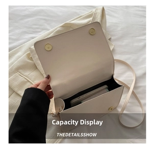 Detail view of cream quilted crossbody bag interior showing storage space for smartphones
