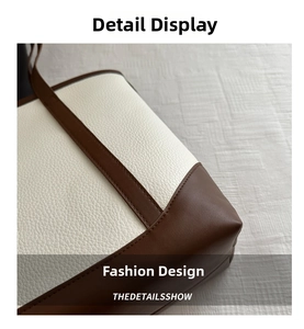 Detailed close-up of stitching on white pebbled and brown smooth leather tote bag