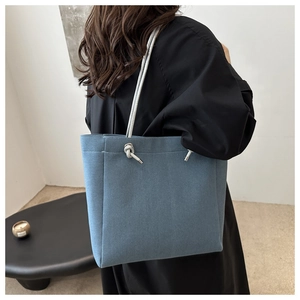 Detail view of the Morandi blue tote bag with a silver-gray braided rope handle