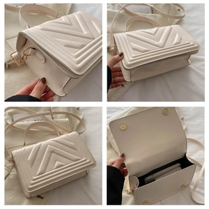 Detail view of cream quilted crossbody bag with golden hardware and interior space