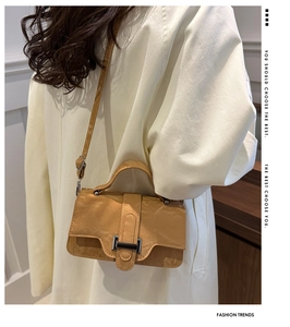 Detail of light brown pleated leather bag showing crossbody strap and side texture