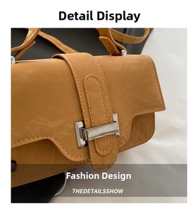 Close-up of caramel brown leather handbag featuring a vintage silver rectangular buckle