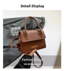 Detailed macro view of the brown litchi pattern leather bag with Fashion lettering