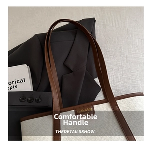 Detail of off-white lychee leather tote bag with brown straps and fashion bag logo