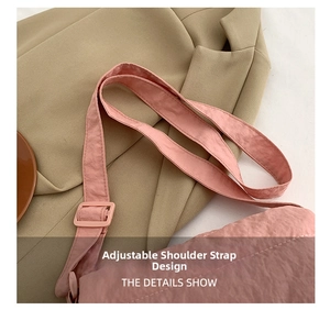Detail shot of the adjustable shoulder strap on a pink padded nylon crossbody bag
