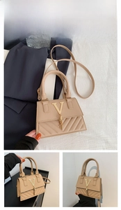 Detail of khaki crossbody bag with quilted texture, metallic V-logo, and chain tassel accents