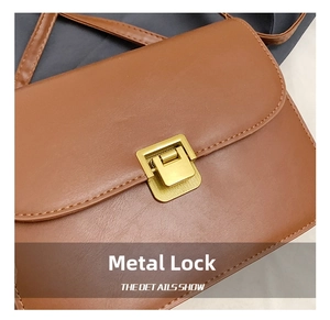 Detailed close-up of premium golden metal hardware clasp on vintage brown leather bag