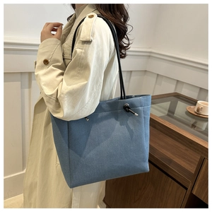Side view of large navy blue tote bag on shoulder with minimalist rope detail