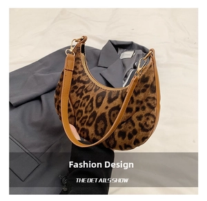 Detail of leopard print half-moon bag featuring faux hair texture and leather strap