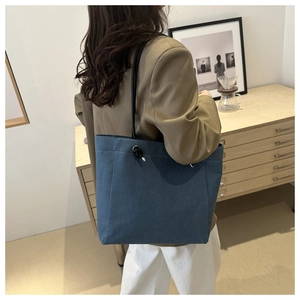 Détail du sac cabas en toile bleue avec poignée en corde noire épaisse et nœud