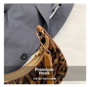 Macro view of leopard print bag showing gold metal hook and zipper hardware details
