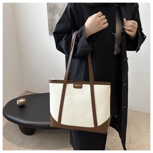 Detail of the high-capacity contrast color tote bag showing fine lychee grain texture