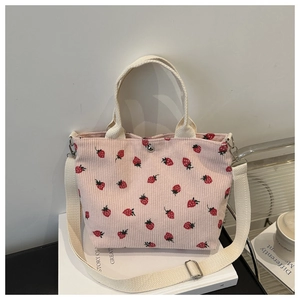 Detail of pink corduroy tote bag with strawberry prints and magnetic snap closure