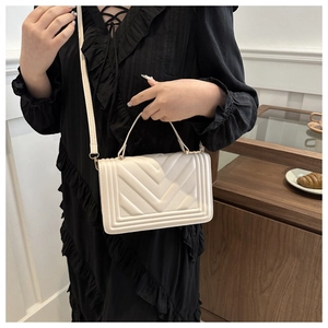 Detail showing cream quilted chevron faux leather handbag with light gold hardware