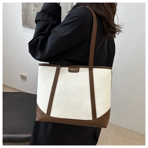 Detail of color-block tote bag with white lychee grain leather and brown fashion logo tag